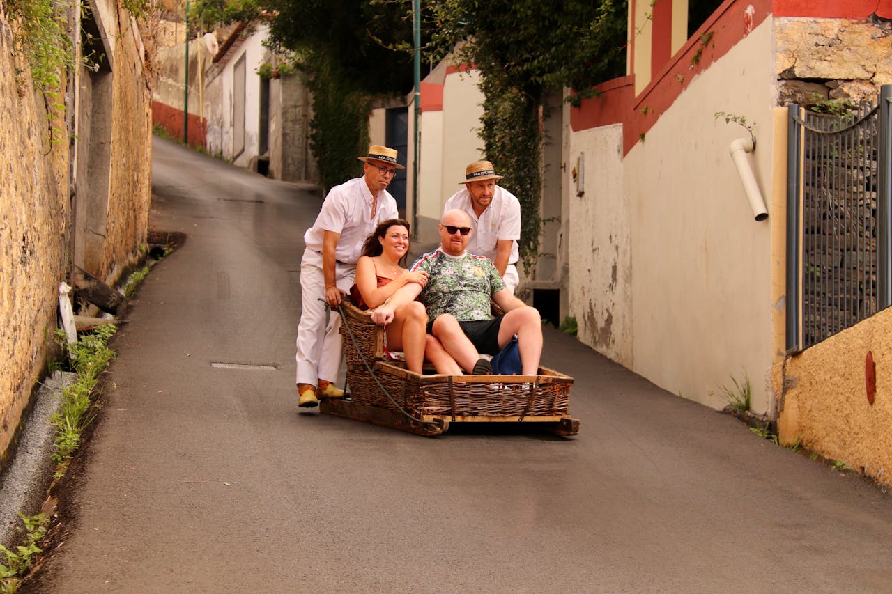 services-04 Tourists enjoying a classic toboggan ride down the steep streets of Funchal, Madeira.